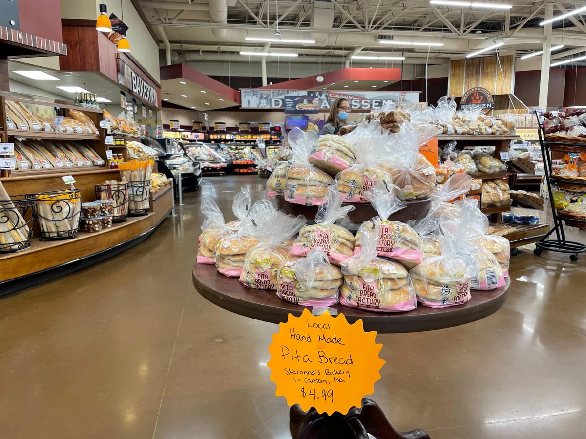Store display stand featuring Sharonna's pita with handwritten Local Hand Made sign